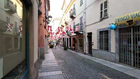 a cobblestone street adorned with flags