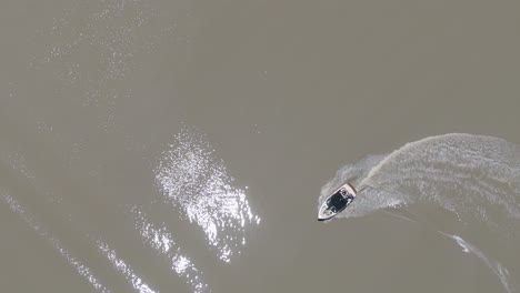 una lancha rápida creando olas en un lago tranquilo