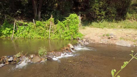 Cacerola-Lenta-De-Cascada-Tranquila-En-Un-Pequeño-Río-Plano-Y-Ribera-En-Tailandia