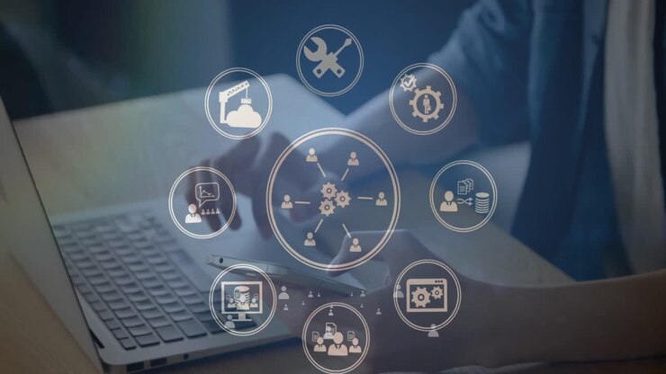 Network of digital icons against mid section of man using laptop and smartphone at office