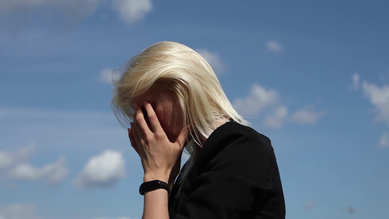 Blond woman having headache because of stress. Sad woman suffering. She is crying and feels despair. Emotional problems