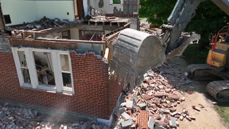 demolition of a brick house using an excavator