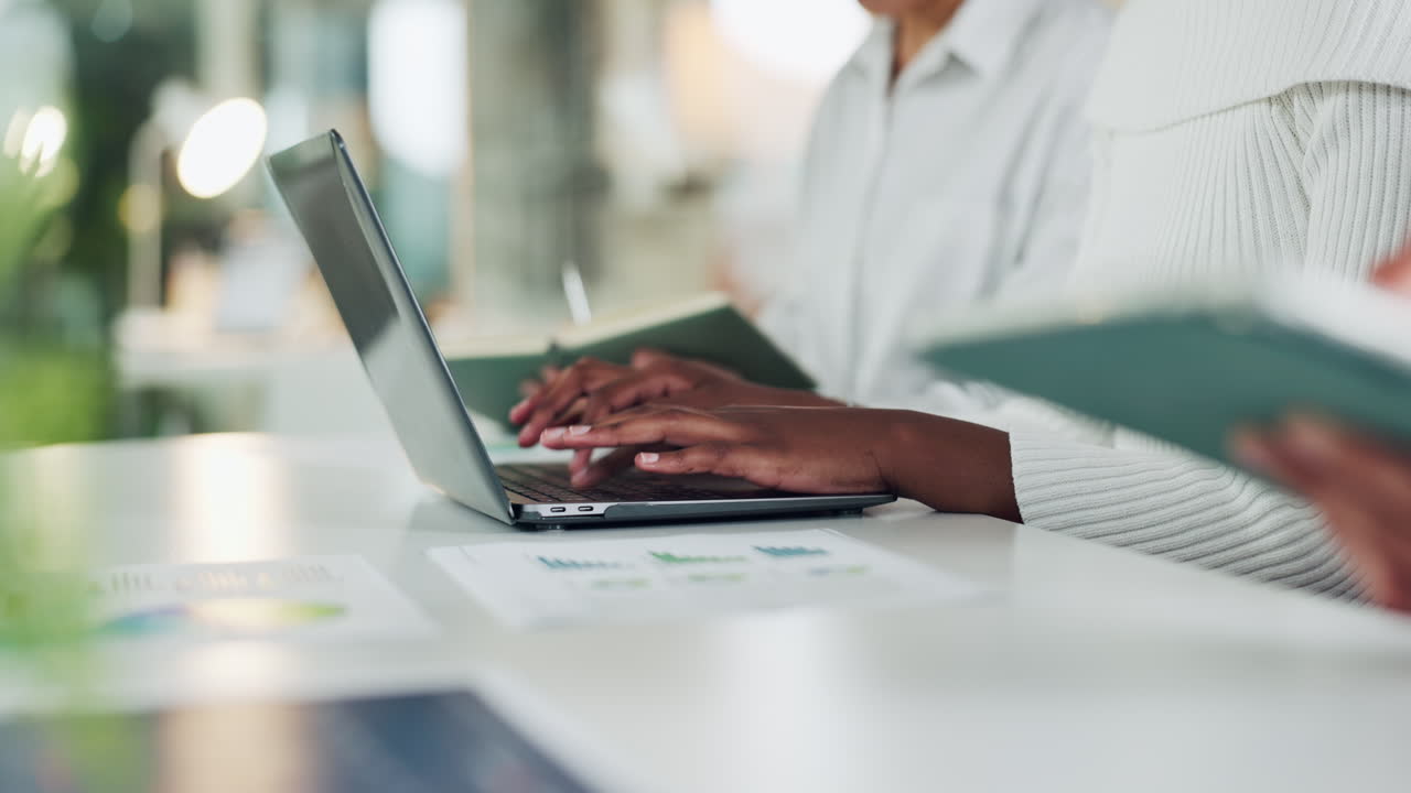 Office scene with people working on laptops and documents