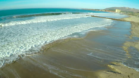 una antena sobre una playa genérica que se dirige al océano con grandes olas y olas rompiendo 1