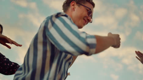 un joven rockando en una fiesta al aire libre. gente alegre bailando en una discoteca.