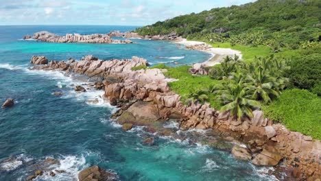 Aerial-view-of-waves-breaking-at-the-unpeopled-coastline-at-Anse-Songe-on-La-Digue,-an-island-of-the-Seychelles