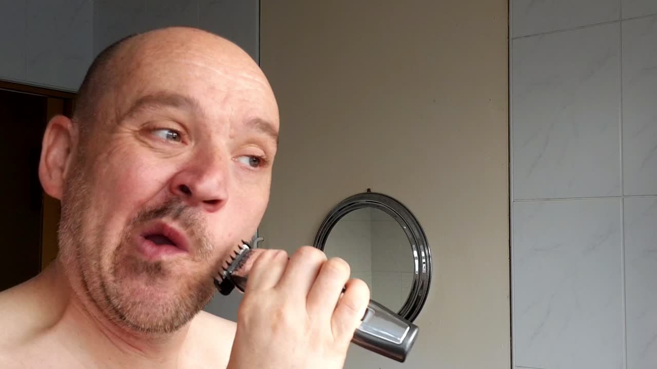 Male shaves with an electric razor