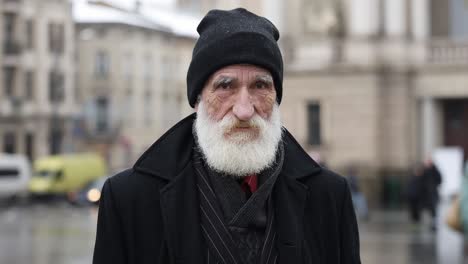 portrait of an elderly man with a white beard wearing a black beanie