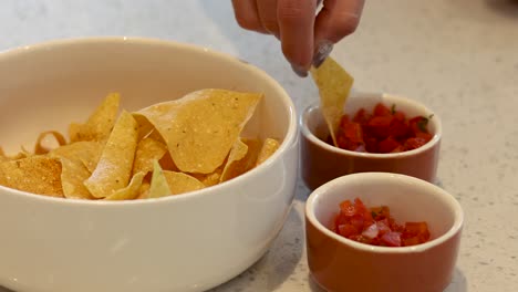 sequential dipping of nachos into salsa sauce