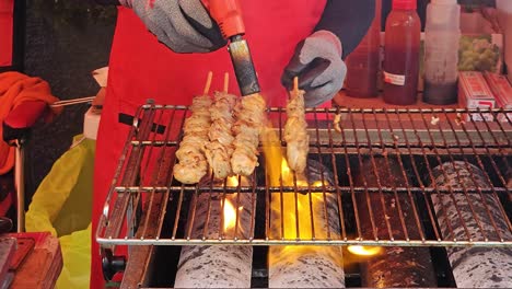 cook torching and grilling barbecue on the griller at the night market