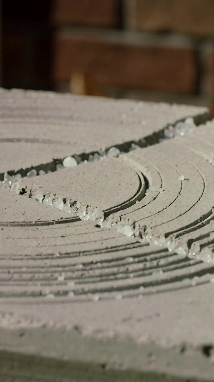 Vertical video: Panning camera showing notched mortar bed at workshop, examining beads in grooves
