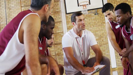 coach explaining game plan to basketball players