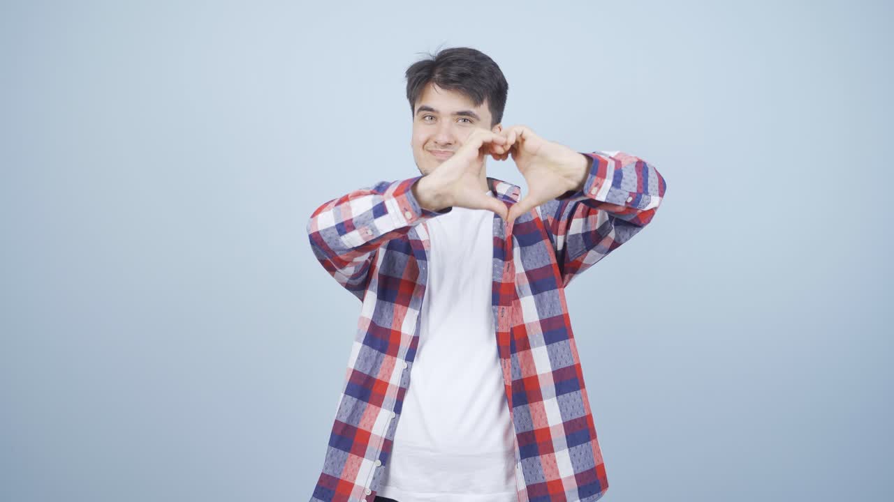 남자가 카메라에 심장 표시를 하고 있습니다.