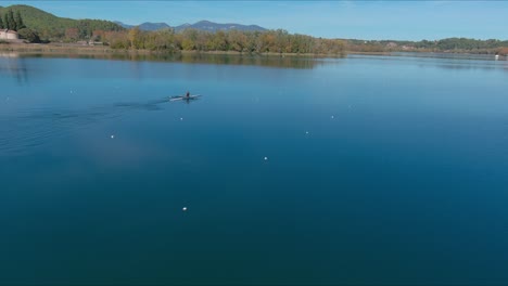 Persona-En-Dos-Barcos-De-Remos-Cruzando-El-Lago-De-Banyoles-En-Otoño,-Girona