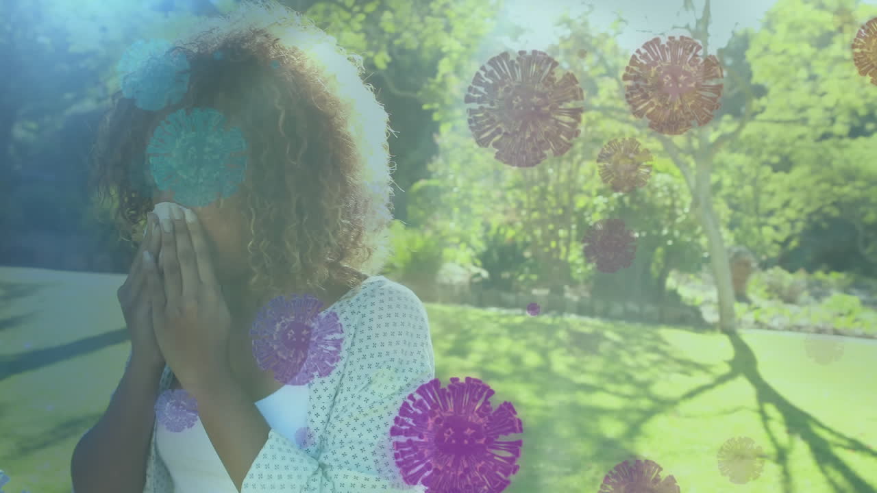 mujer afroamericana soplando la nariz sobre el coronavirus células covid19 flotando