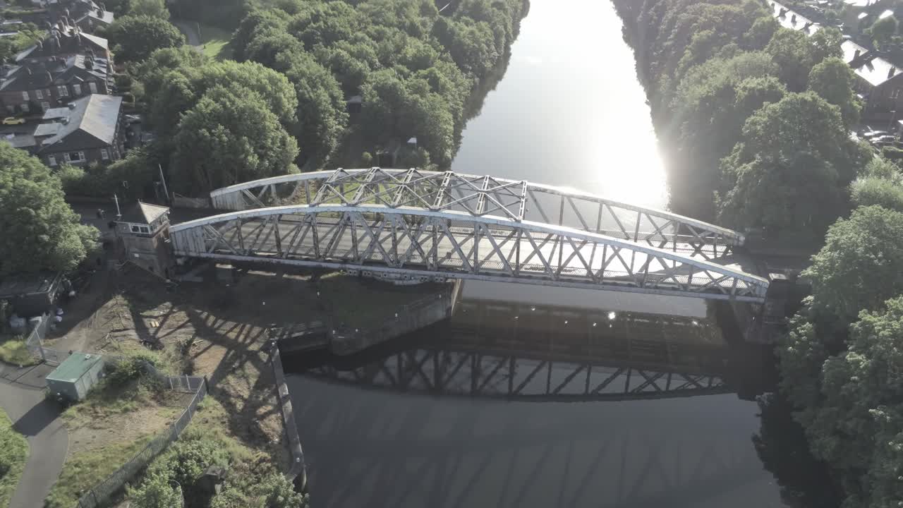 일출 때 맨체스터 선박 운하를 가로지르는 경치 좋은 구식 강철 아치형 교통 인도교 궤도