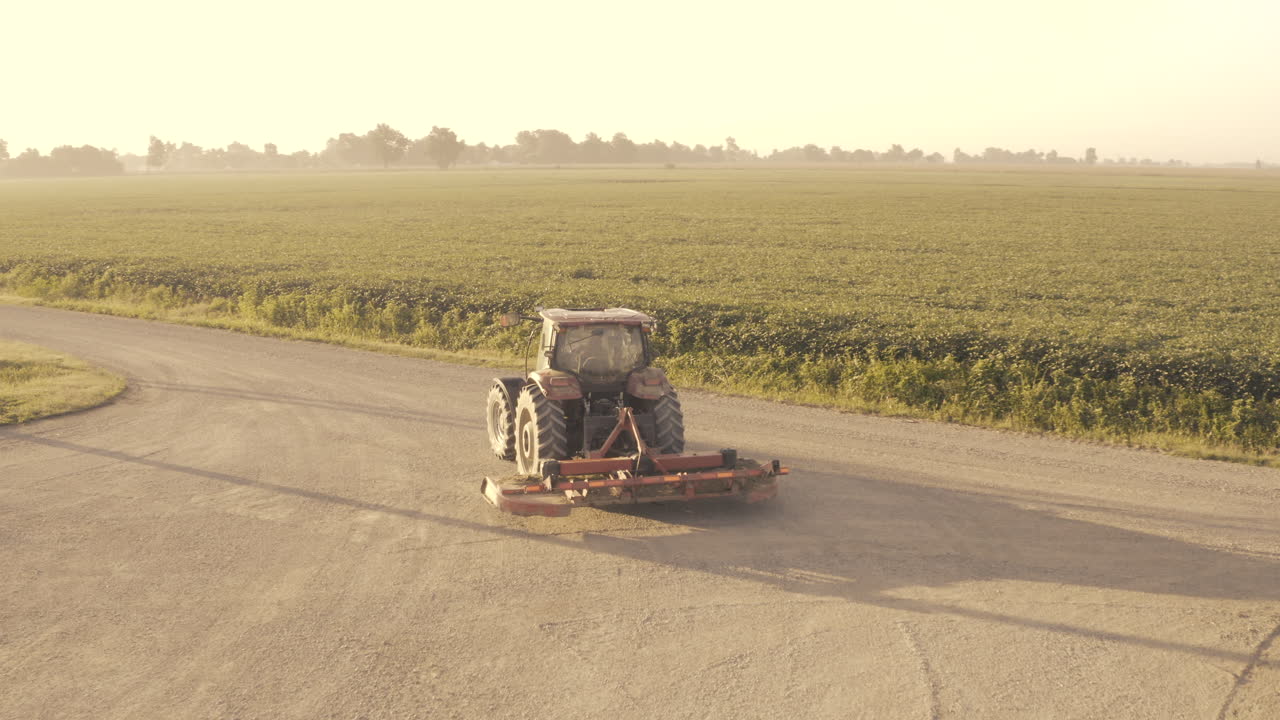 A tractor pulls out onto the road on rural farmland.