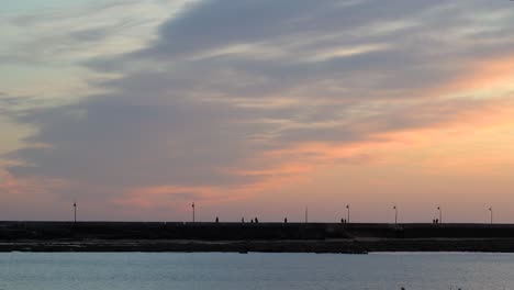 Silueta-De-Puente-Con-Gente-Y-Hermoso-Cielo-De-Puesta-De-Sol-Con-Nubes