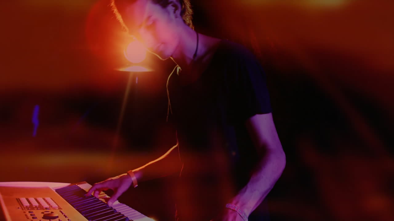 man playing keyboard on stage, showcasing music technology with neon streaks and light flares