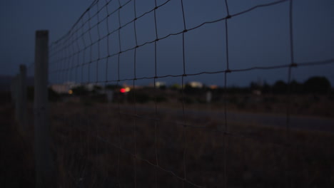evening view of a country road along the wire metal fence