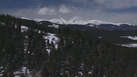 Mount-Blue-Sky-Evans-Evergreen-Colorado-aerial-drone-parallax-14er-Rocky-Mountain-North-Turkey-Creek-Rd-Marshdale-landscape-spring-snow-melting-morning-sunny-clouds-forward-pan-up-reveal-motion