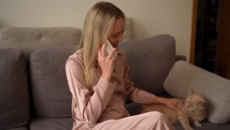 mujer hablando por teléfono con gato en el sofá