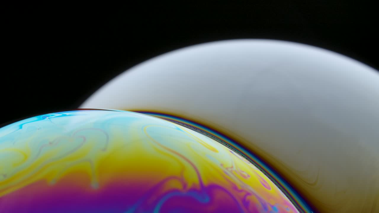 Soap bubble macro rainbow colors creating multicolored patterns. Colorful foam soap bubble slow motion. Very similar to other galaxy planets. Close up