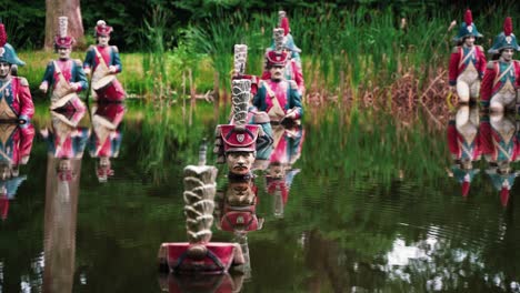 Statuen-Von-Soldaten,-Die-Einen-Tiefen-Wasserteich-überqueren,-Vergrößern-Sie-Unsere-Ansicht