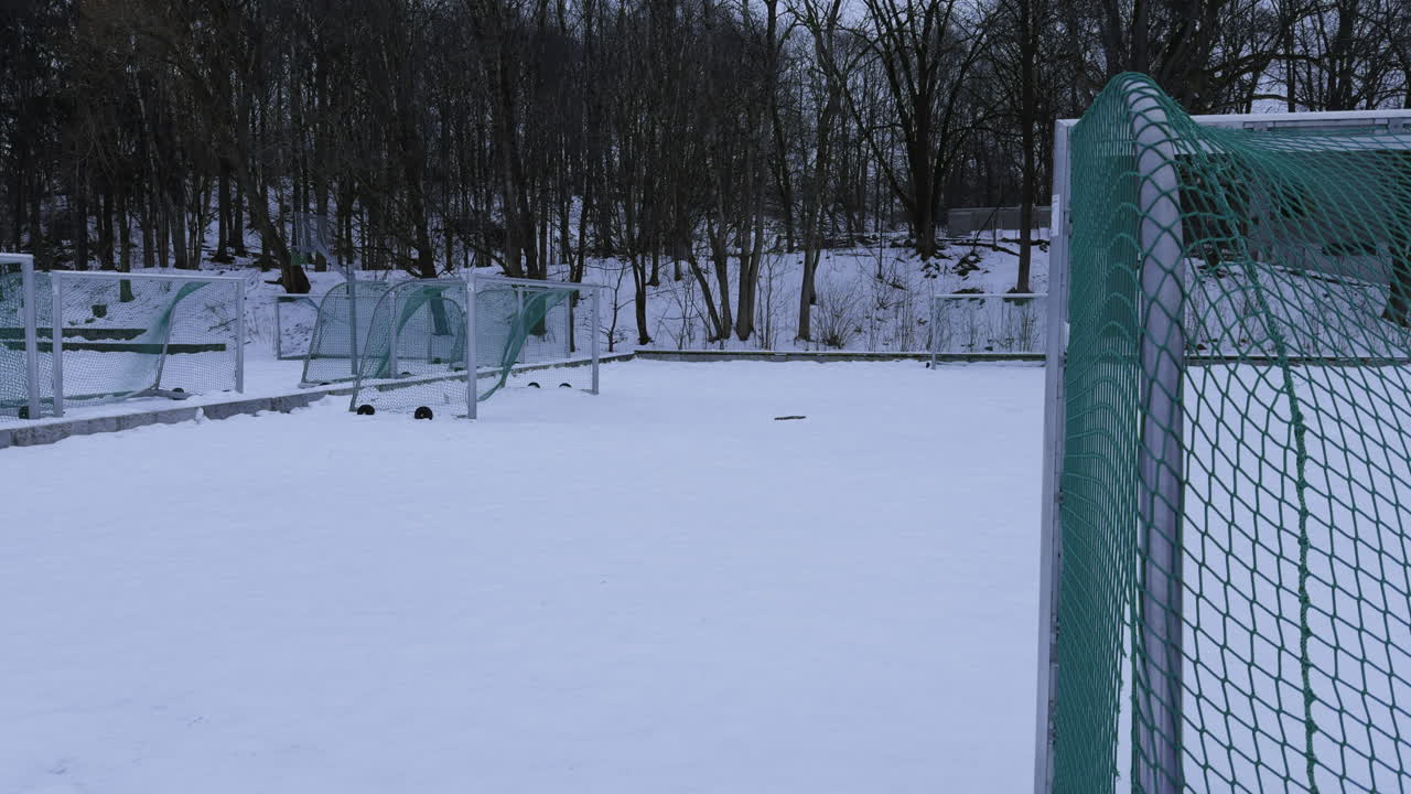 Široký záběr fotbalových branek stojících ve sněhu, protože přišla zima a sezóna v Norsku skončila.