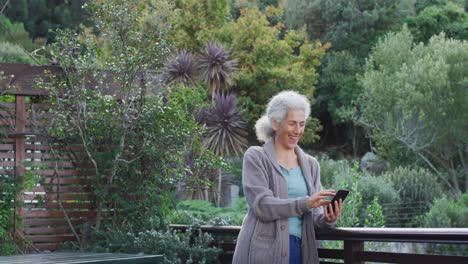 Porträt-Einer-älteren-Frau-Mit-Gemischter-Abstammung,-Die-Ihr-Smartphone-Auf-Dem-Balkon-Benutzt