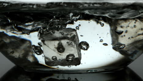 ice cubes falling into a bowl of water