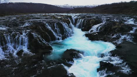 aerial flyover beautiful blue colored glacier water of river flowing and falling down bruarfoss waterfall in iceland