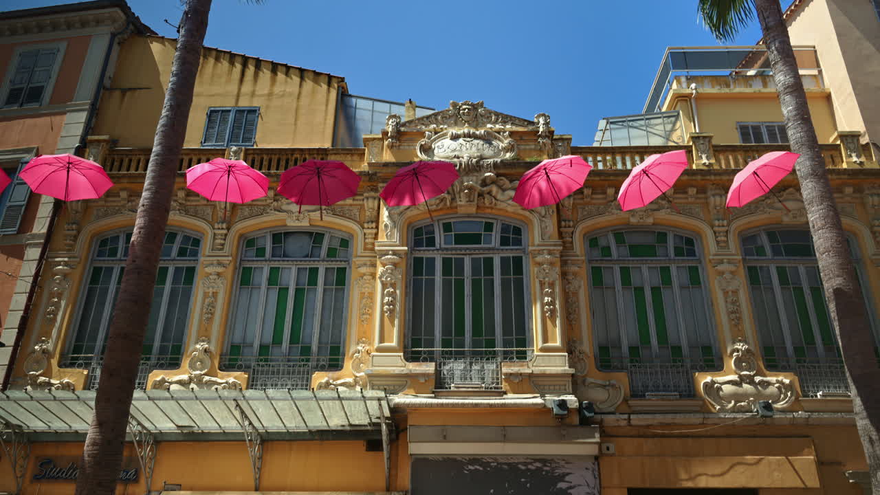 Rows of pink umbrellas above the streets of the old town in Grasse, France