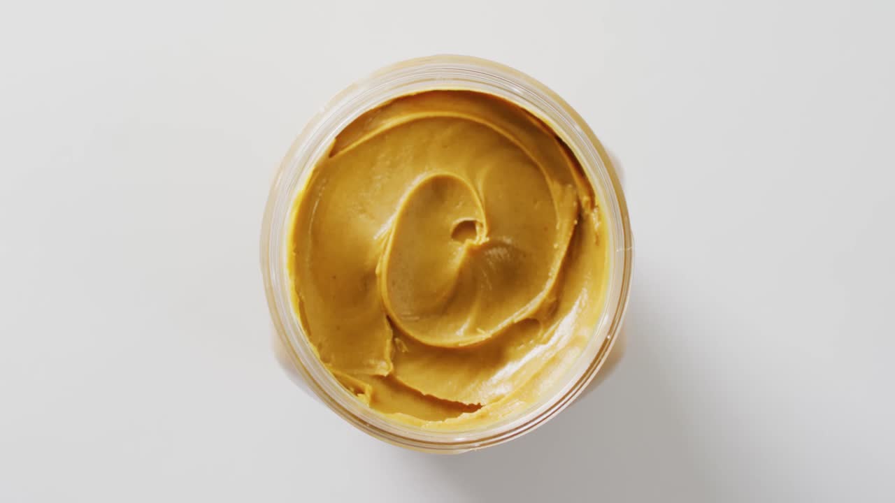 ⁇ 색 배경 에 땅콩 버터 가 있는 항아리 의 클로즈업 비디오