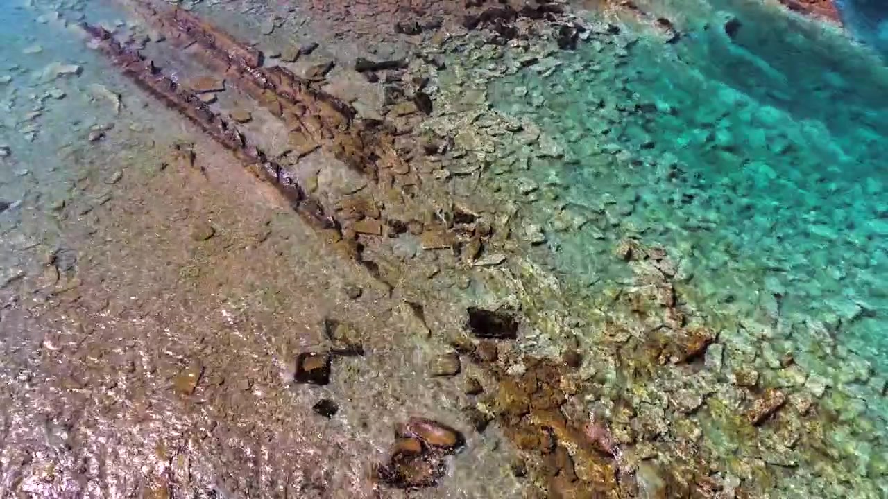 Vista aerea di acqua limpida turchese su una costa rocciosa