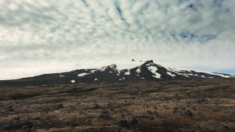 Drone-aerial-pan-shot-of-gorgeous-snow-capped-mountains-in-a-desert-and-rocky-area