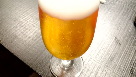 close up shot of golden beer,soaring bubbles and white foam