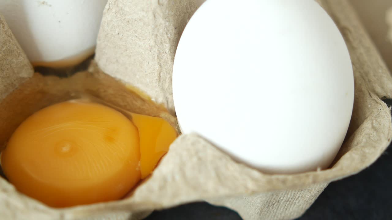 Close up of a cracked egg in an egg carton