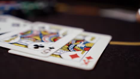 a close-up view of a playing card with the king of diamonds displaying intricate design in a tavern-style setup for a card game night