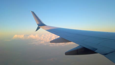 Airplane-flying-above-clouds-in-clear-sky