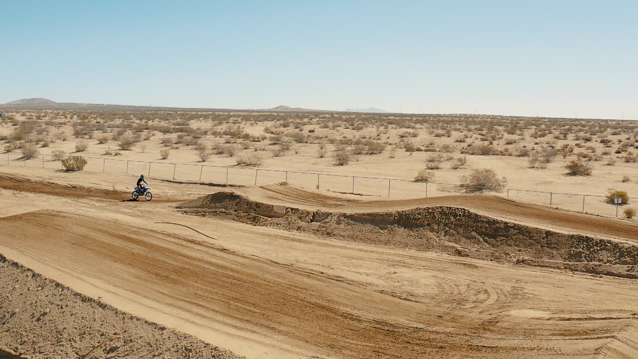 Imagens aéreas de drone, moto de motocross no ar em câmera lenta, Deserto de Mojave.