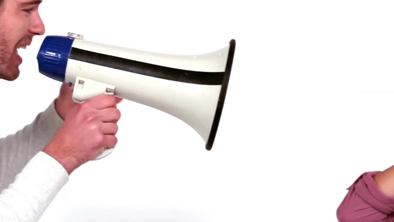 남자 가 메가폰 을 통해 파트너 에게 소리 지르고 있다