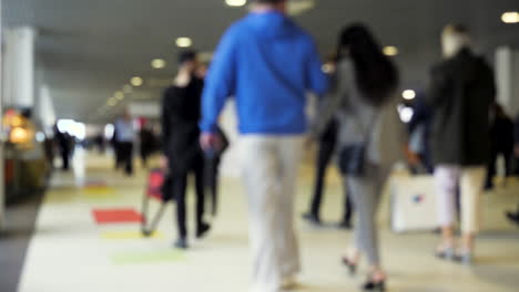 Blurred image of a large crowd of people in an indoor public space