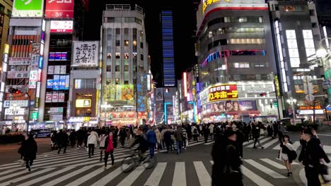 crowds crossing a vibrant, illuminated urban crosswalk