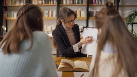 woman tutoring students in a library