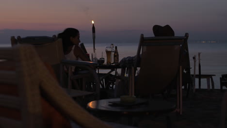 couple spending evening in cafe on the beach