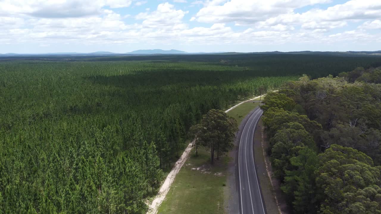 drone descendiendo sobre la carretera y el bosque vacíos