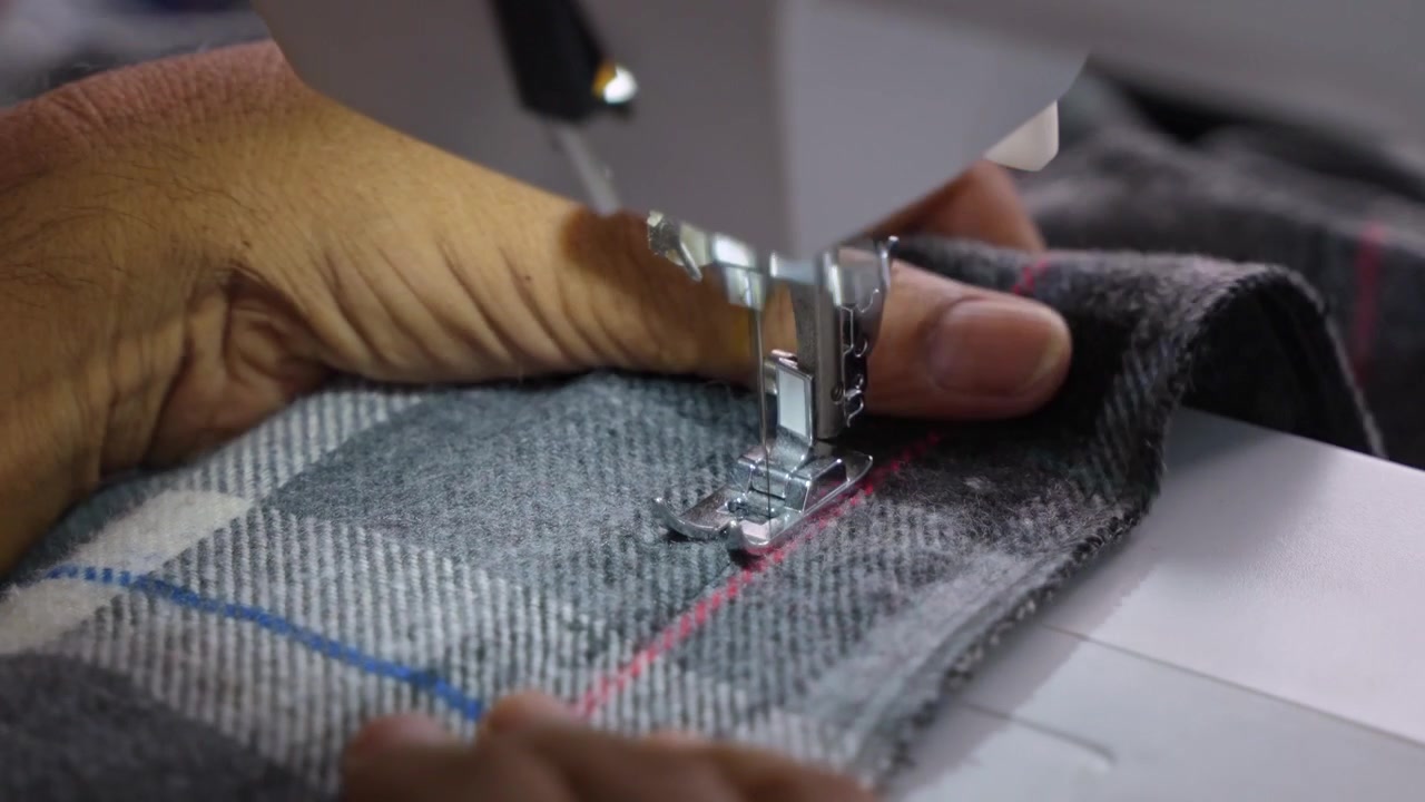 Man Stitching Clothes Using an Electric Sewing Machine