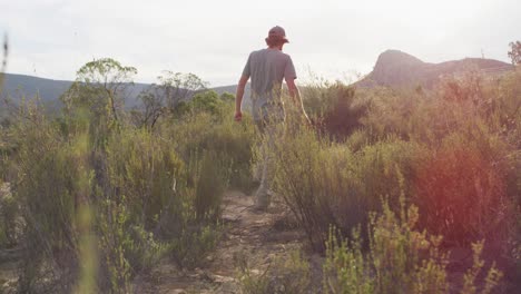 hombre caucásico sobreviviente caminando por un sendero a través del desierto