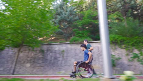 the disabled young man drives his wheelchair fast and his friend accompanies him.